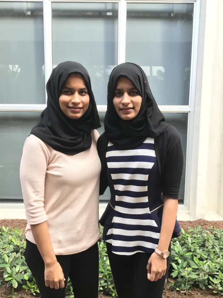 Amin sisters posing in front of home window